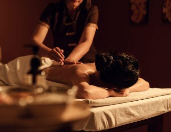 Relaxation woman back massage with masseur in cosmetology spa centre. Relaxing female customer get service aromatherapy massage with masseuse in spa salon. Selective focus.